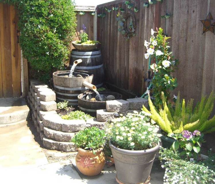 pequena fonte de água em forma de canto de jardim com barris de vinho antigos