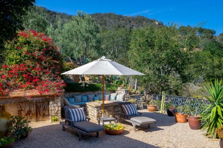ideias de jardim para lugares favoritos espreguiçadeiras-sofá-ideia-parede de pedra-estilo mediterrâneo-guarda-chuva