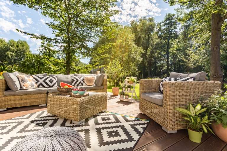 Tendências de móveis de jardim para 2020 Grupo Lounge no terraço com móveis de vime e carpete ao ar livre