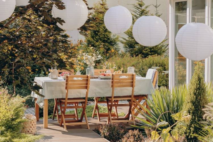 Lâmpadas redondas acima da mesa de jantar ao ar livre em estilo country rústico