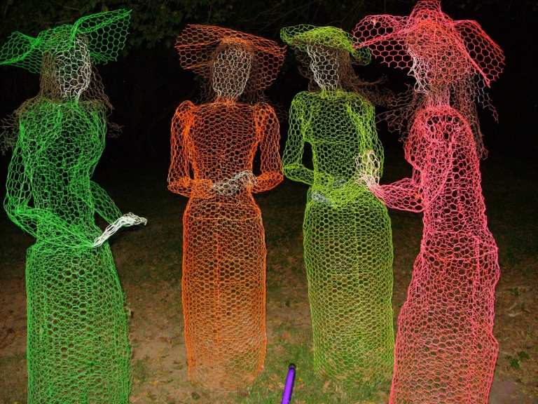 Fantasmas coloridos como decorações de jardim de Halloween na forma de mulheres com chapéus