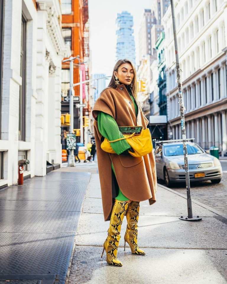 Botas com estampa de cobra amarela, vestido verde e poncho marrom