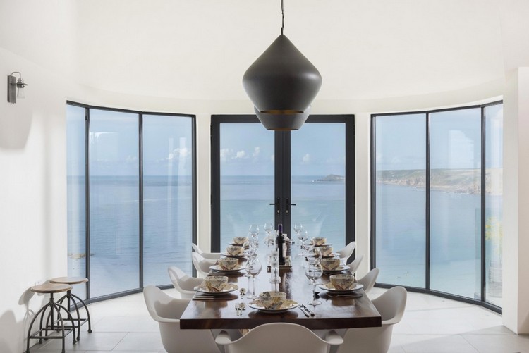 vidro-frente-sala-de-jantar-retangular-mesa-de-jantar-cadeiras-brancas-pretas-luzes suspensas