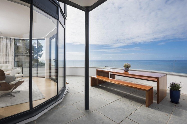 casa-frente-terraço-madeira-mesa de jantar de vidro-vista para o mar