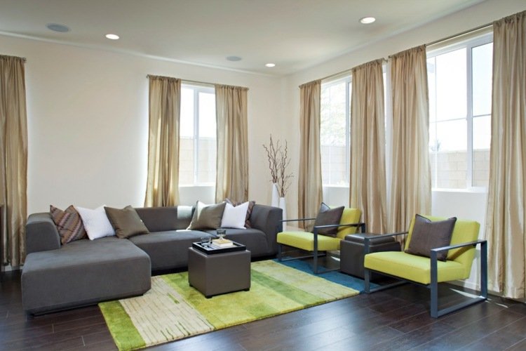 Poltrona com tapete verde da sala de estar com cortinas para piso laminado
