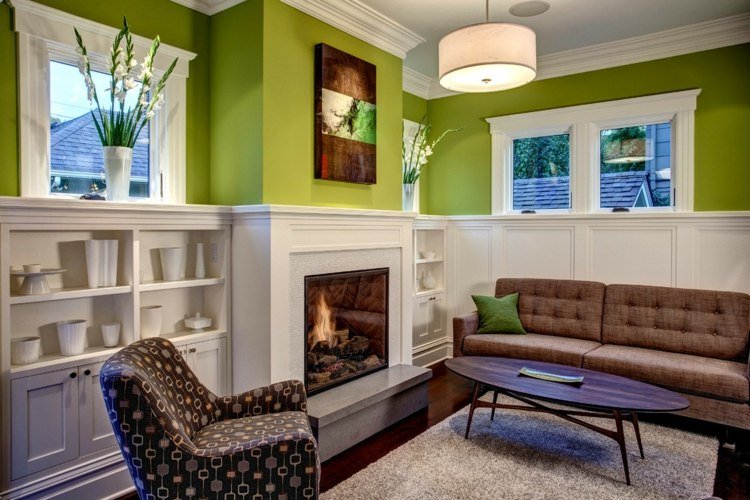 Design verde da cor da parede da sala de estar com prateleiras com consolo de lareira