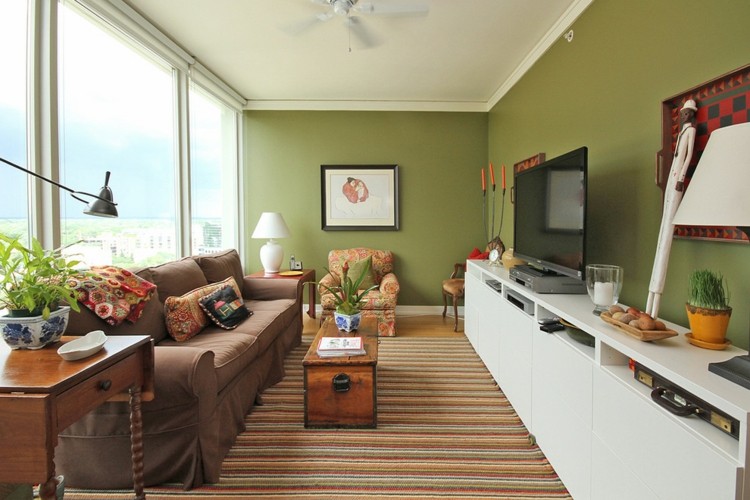 Projeto verde da parede da sala de estar com listras em carpete sofá cor chocolate