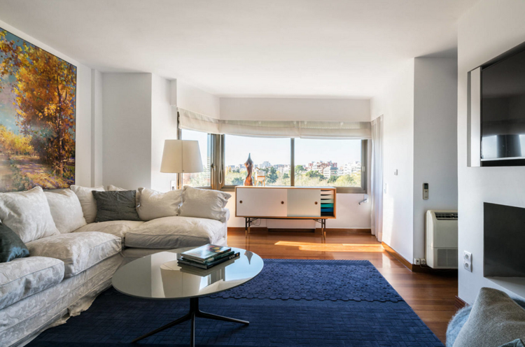 Cortinas de tecido para sofá branco com tapete azul cobalto na sala de estar