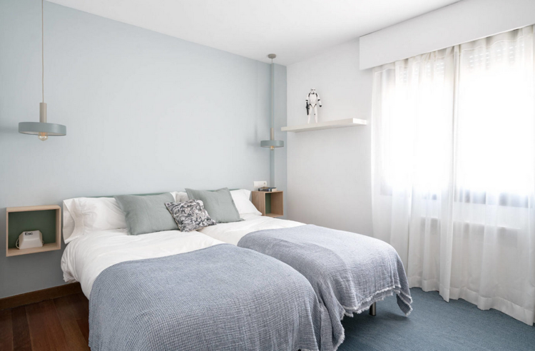 Quarto infantil com duas camas de solteiro pintura azul pastel na parede