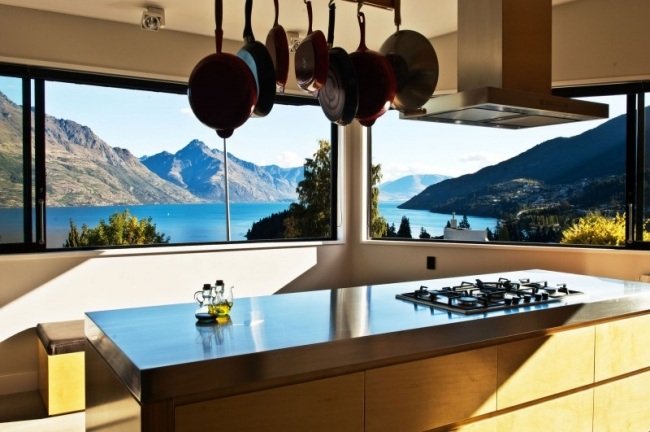 Cozinha com janela panorâmica de frente para o lago cozinha ilha exaustor painéis de madeira