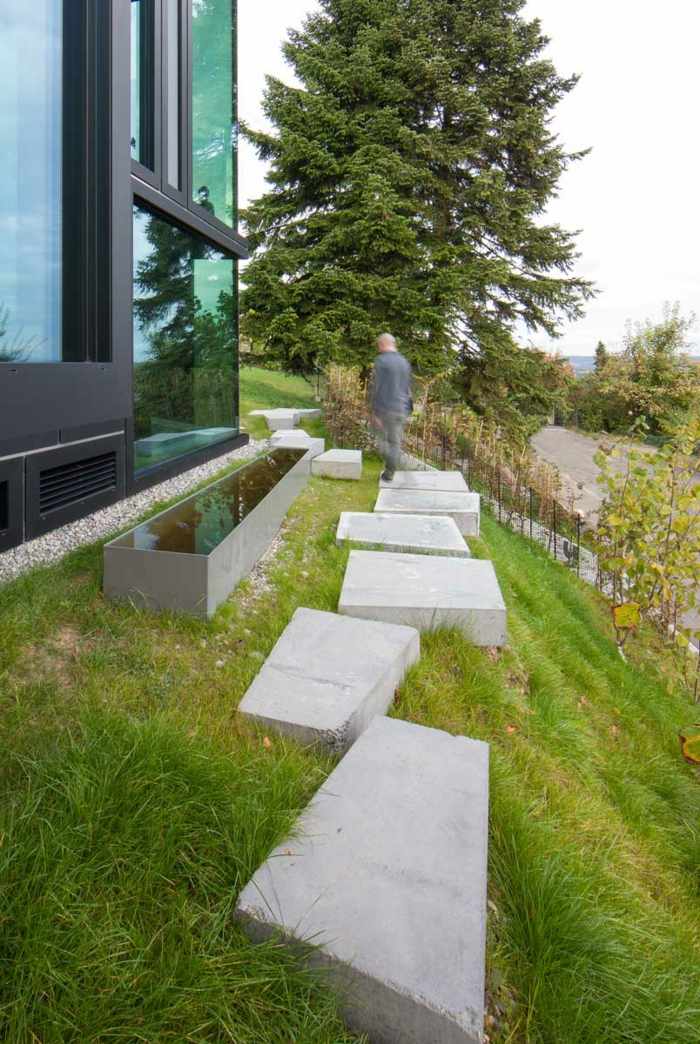 caminho de jardim lajes de concreto gramado inclinação janela de vidro