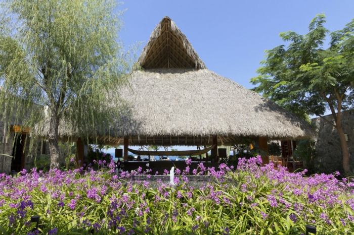 casa no jardim de flores no telhado de palha do méxico