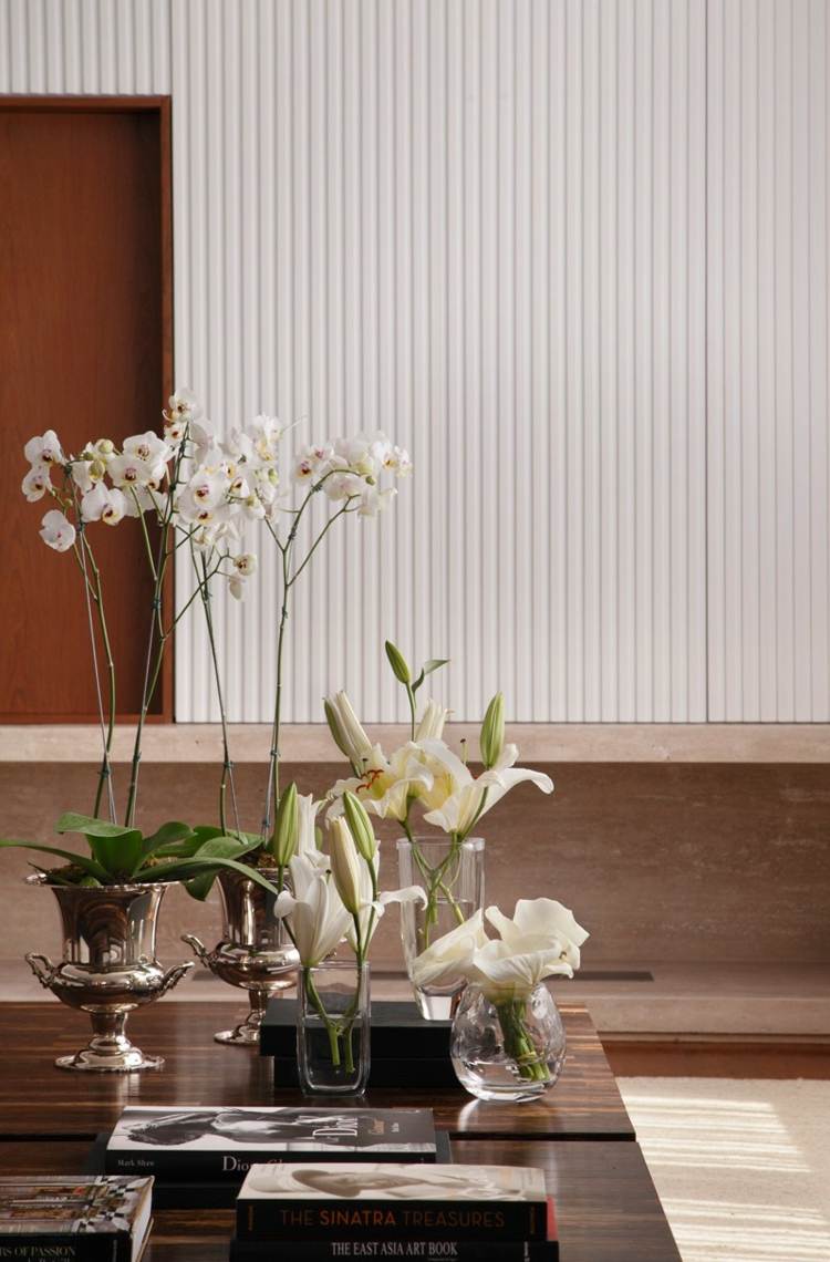 interior da casa em branco e decoração em madeira escura orquídeas lírios