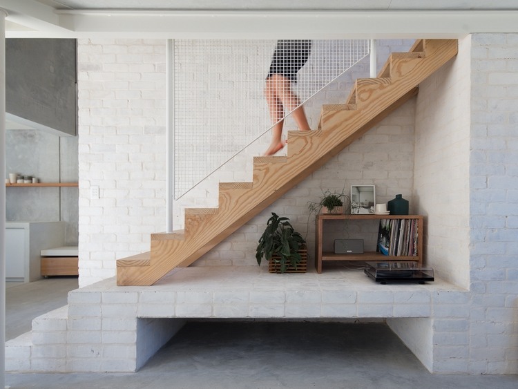 escada de madeira com proteção contra quedas de ferro em branco como uma grade e móveis retrô