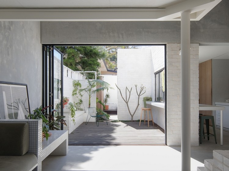 pátio com belos elementos de design e paredes de tijolos brancos com plantas