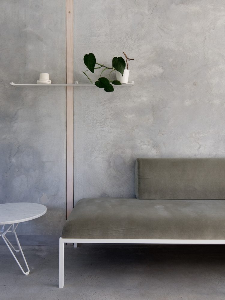paredes cinza feitas de concreto em combinação com um sofá sutil e uma mesa lateral de mármore