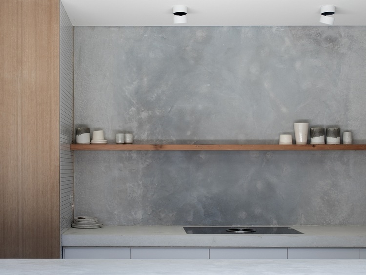 cozinha compacta com prateleiras de madeira minimalistas e parede de concreto