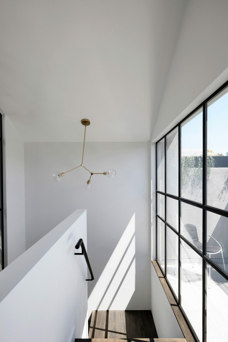 área de escada simples com janelas grandes e detalhes em metal preto