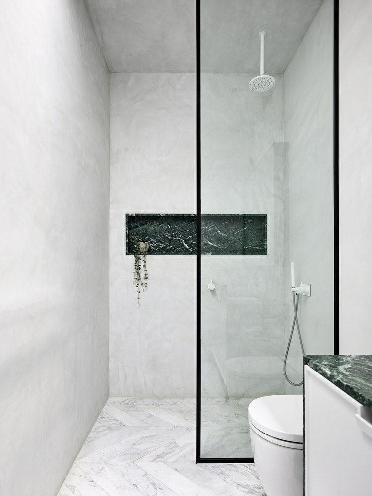 tampo de mármore verde como destaque no banheiro de pedra natural