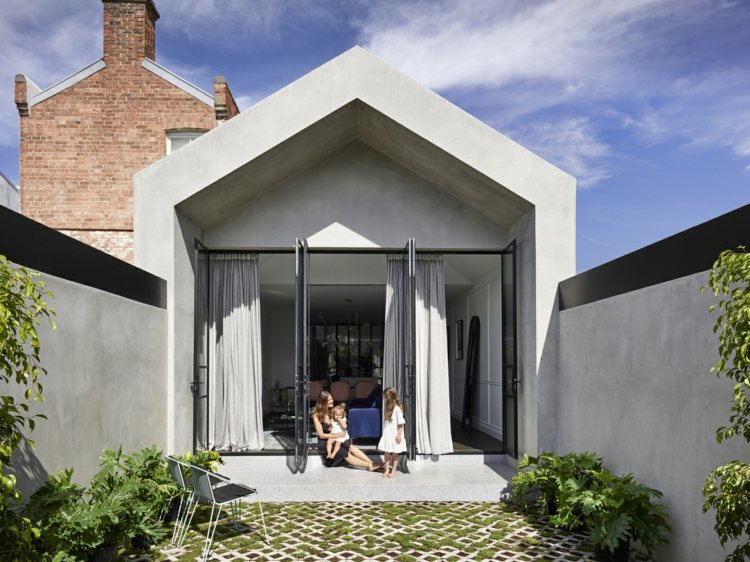pequeno jardim com terraço e fachada moderna em aparência de concreto