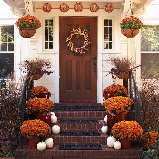 Decoração outonal - cor laranja com abóboras amarradas na porta da escada