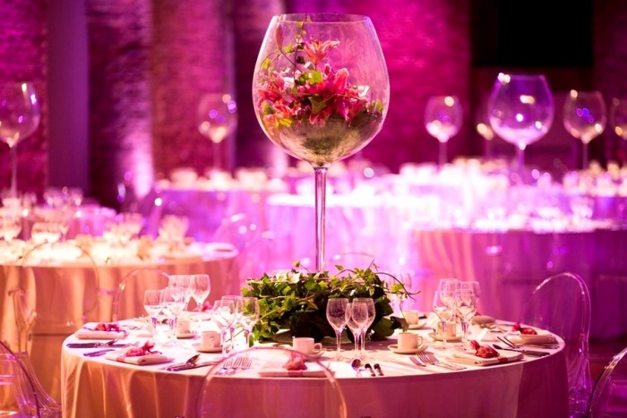 Estante de vidro com arranjo de flores e decoração de casamento em fúcsia