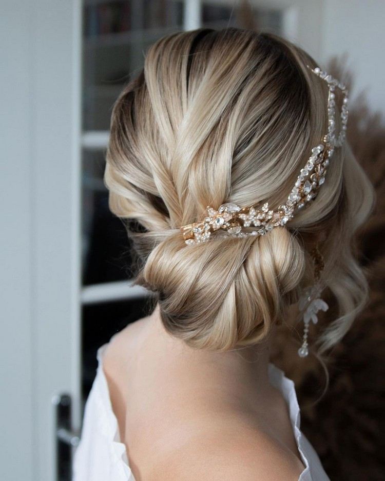 Coque de penteado de casamento ao lado com acessórios de cabelo brilhantes
