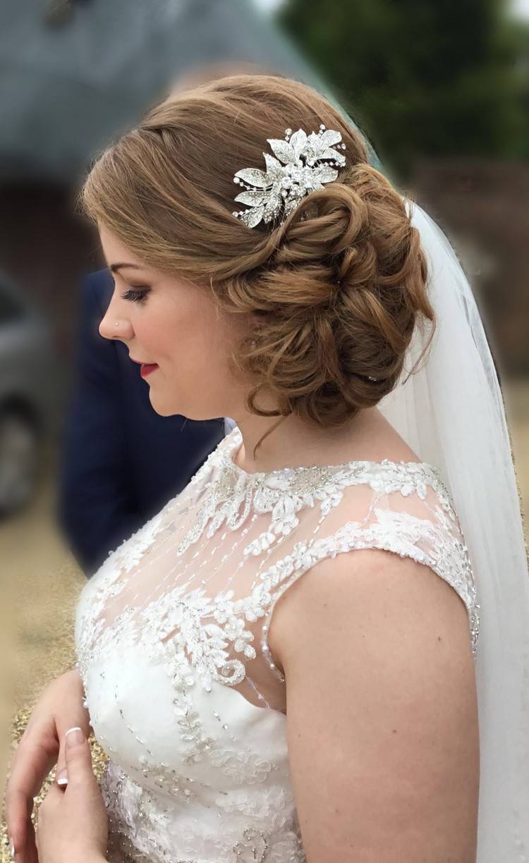 Penteado de noiva trançado lateralmente com véu e acessórios para o cabelo
