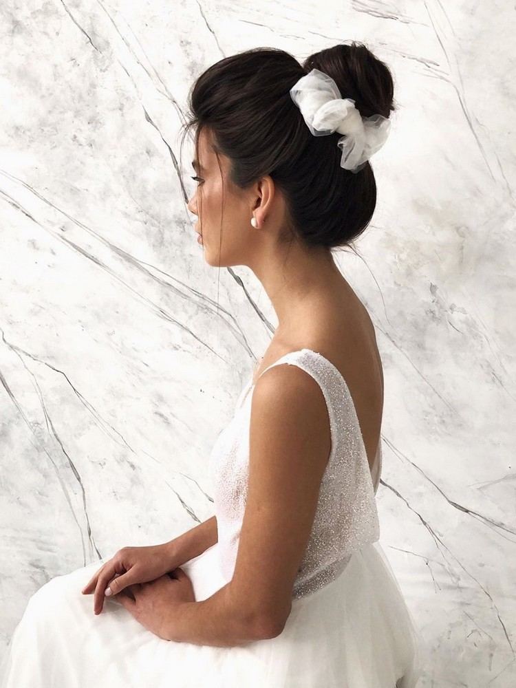 Penteado de noiva com coque alto e volumoso com laço de tule