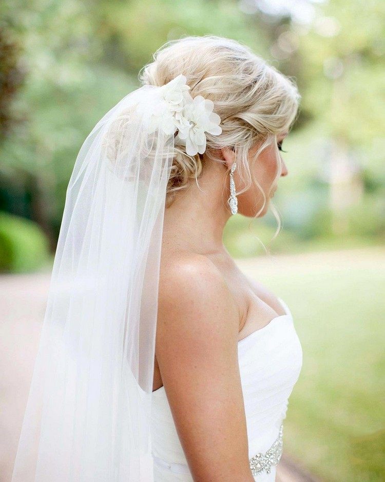 Penteado de noiva com coque profundo com véu sobre ele