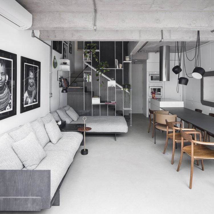 Salas de estar em preto e branco e cinza com um sofá modular e paredes brancas e fotos em preto e branco como decoração de parede