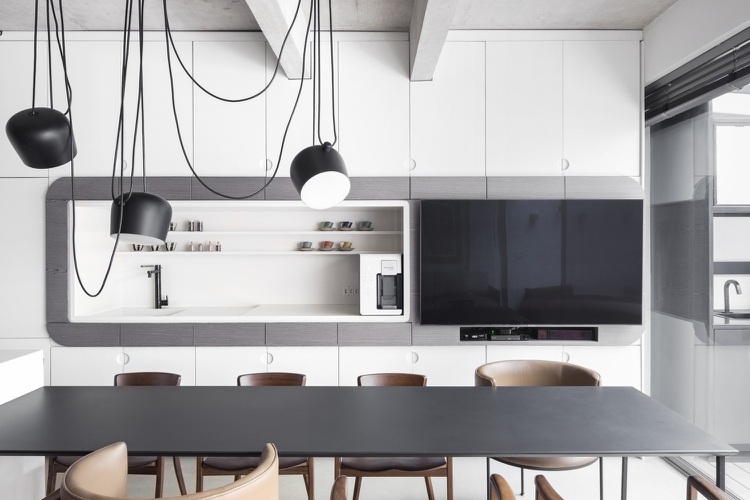 Cozinha minimalista moderna com armários frontais brancos e mesa de jantar preta com luz pendente