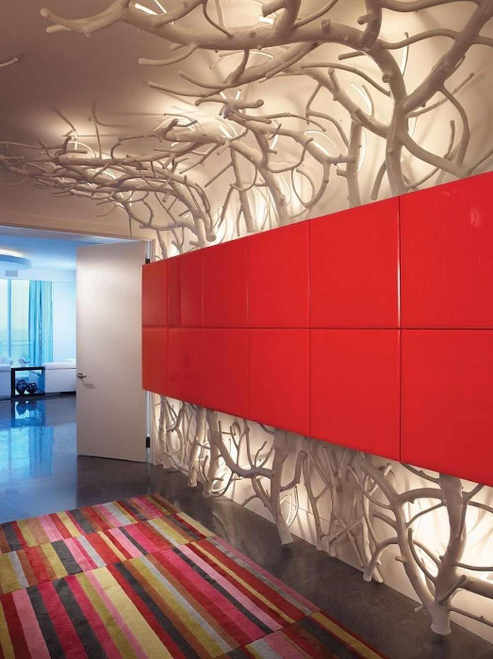 design artístico e iluminação indireta no corredor atrás de painéis de parede vermelhos e galhos