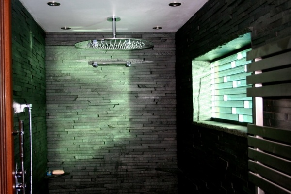 banheiro moderno com chuveiro com efeito de chuva na parede de pedra