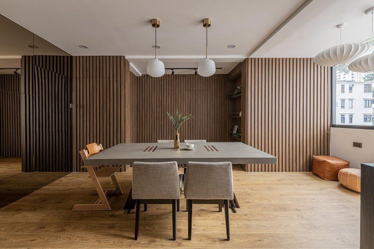 Sala de jantar em estilo japonês com mesa de tampo de concreto e piso de madeira