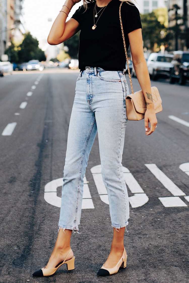 Use jeans de perna reta em azul claro com uma camiseta preta e um bolso nude