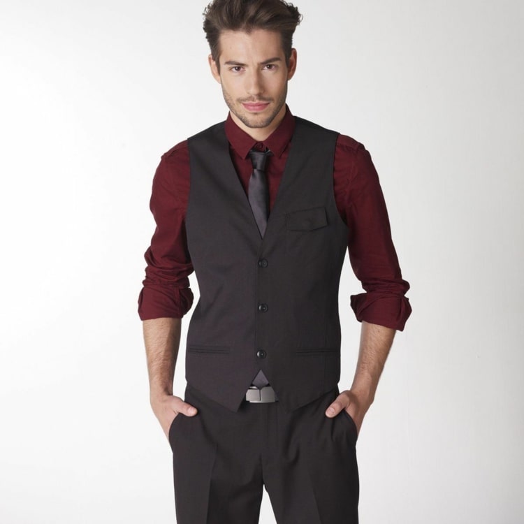 Calça e colete pretos com uma camisa vermelho vinho e gravata