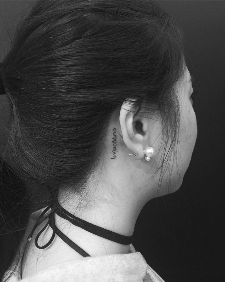 pequenos motivos de tatuagem fonte vertical discreto monocromático mulher atrás da orelha