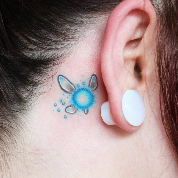 mini desenho de tatuagem colorida azul cinza branco atrás da orelha