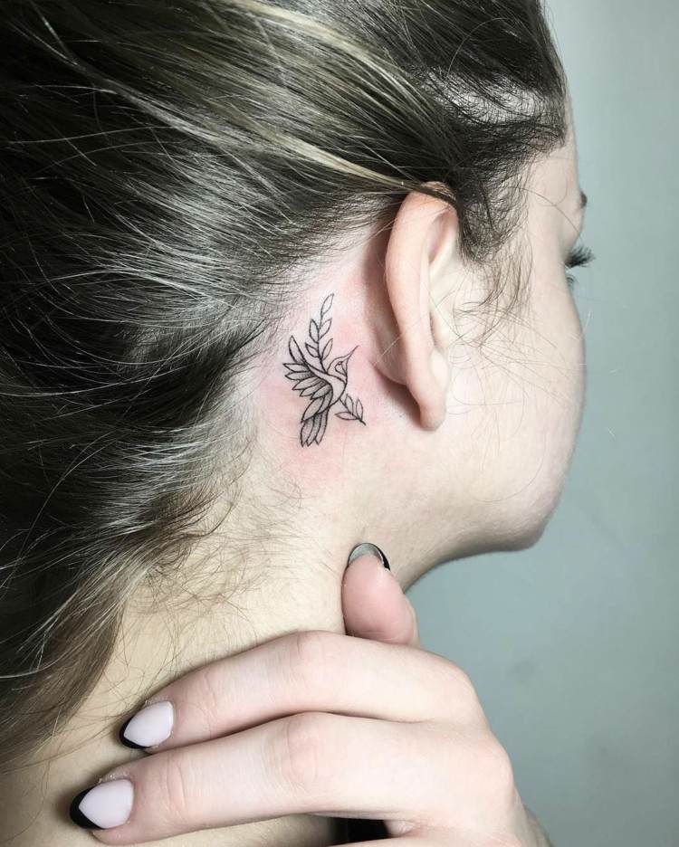 pequenas tatuagens pássaros se ramificam atrás das orelhas das mulheres