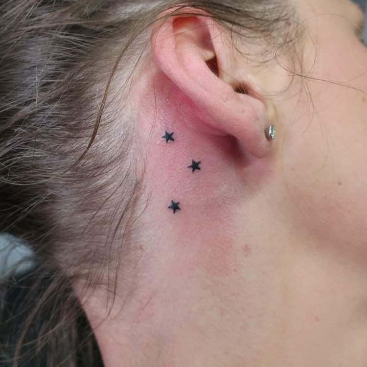 pequenas estrelas com motivos de tatuagem atrás da orelha para mulheres