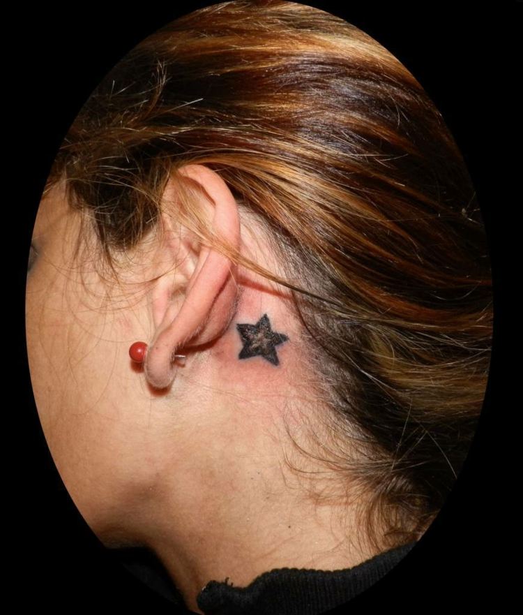 pequena tatuagem de mulher estrelada atrás da orelha