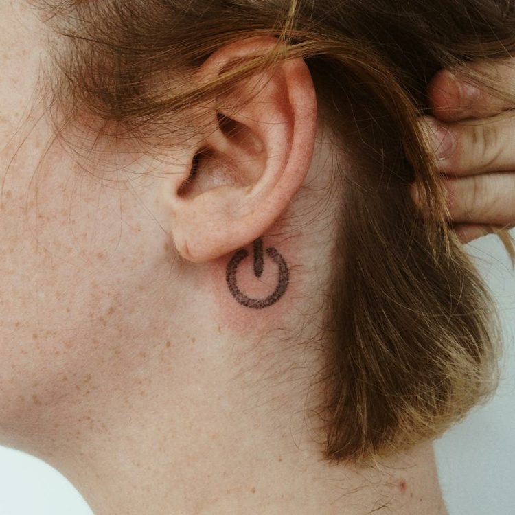no botão desligado, pequenos motivos de tatuagem atrás da orelha da mulher