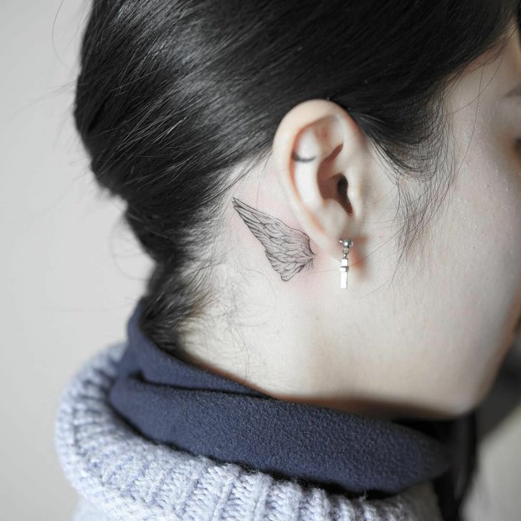 pequenas tatuagens asas atrás da orelha mulher discreta