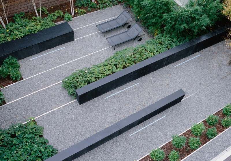 Pequeno jardim com espreguiçadeiras e quintal coberto