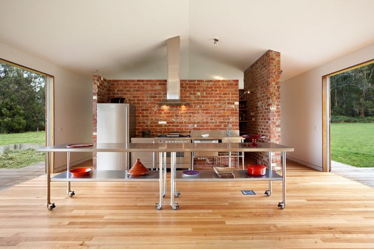 exterior de tijolo de clinquer cozinha moderna acento parede exaustor mesa metal piso de madeira jardim