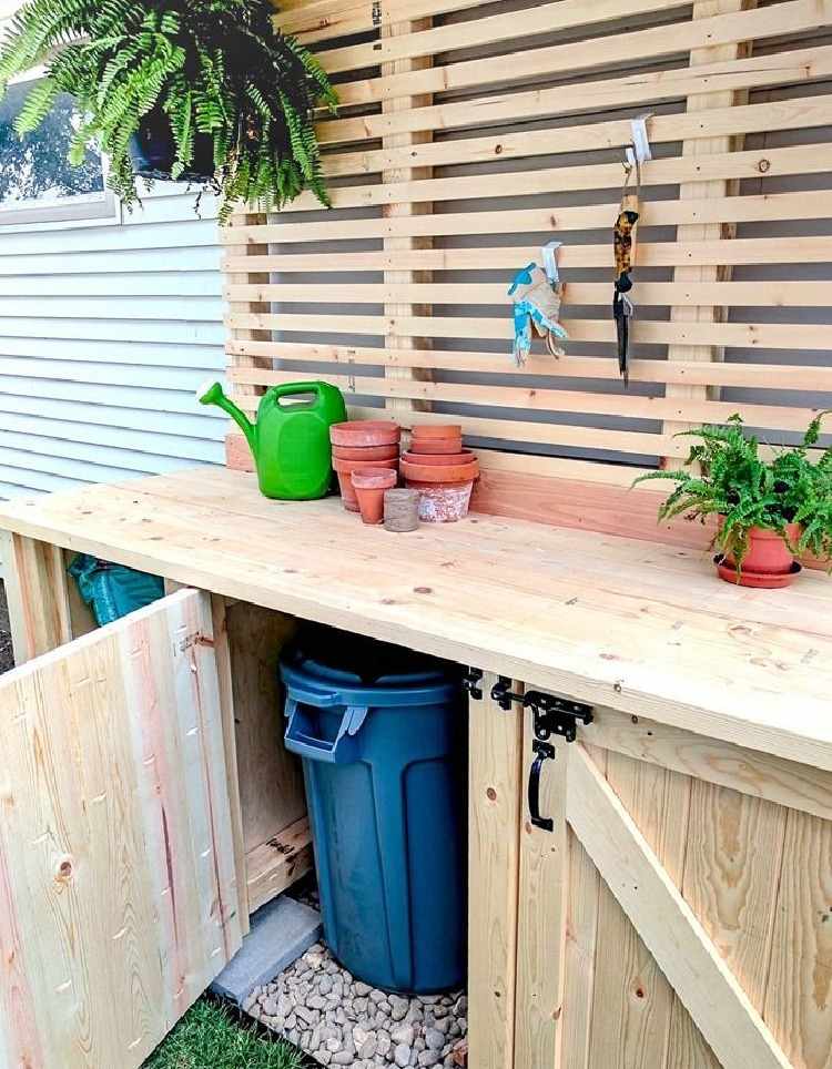 esconder agradável canto de compostagem com construção de armário de jardim de madeira com portas e bancada