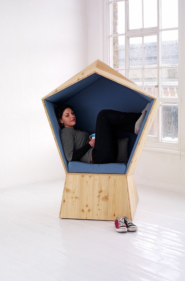 Crie uma peça de mobília relaxante com estofamento azul em um canto de leitura de madeira