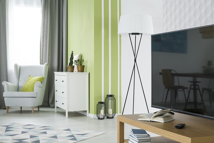 Sala de estar em verde e branco com parede de acento e papel de parede em padrão geométrico