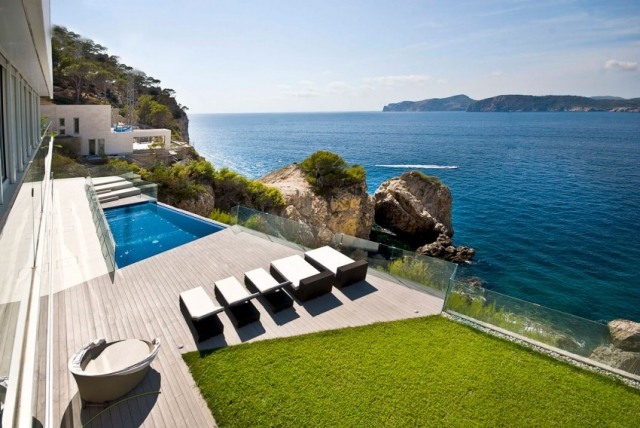 Villa luxuosa em arredores rochosos em Maiorca - deck de madeira com piscina infinita